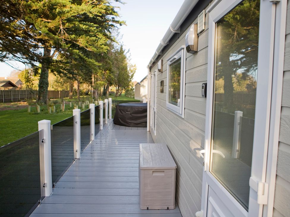A deck with storage box and railing at Orchid 9 Christchurch