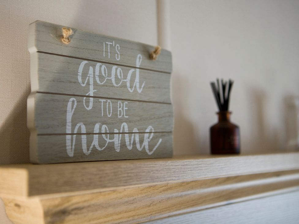 A sign saying it's good to be home and a diffuser on a shelf at Orchid 9 Christchurch