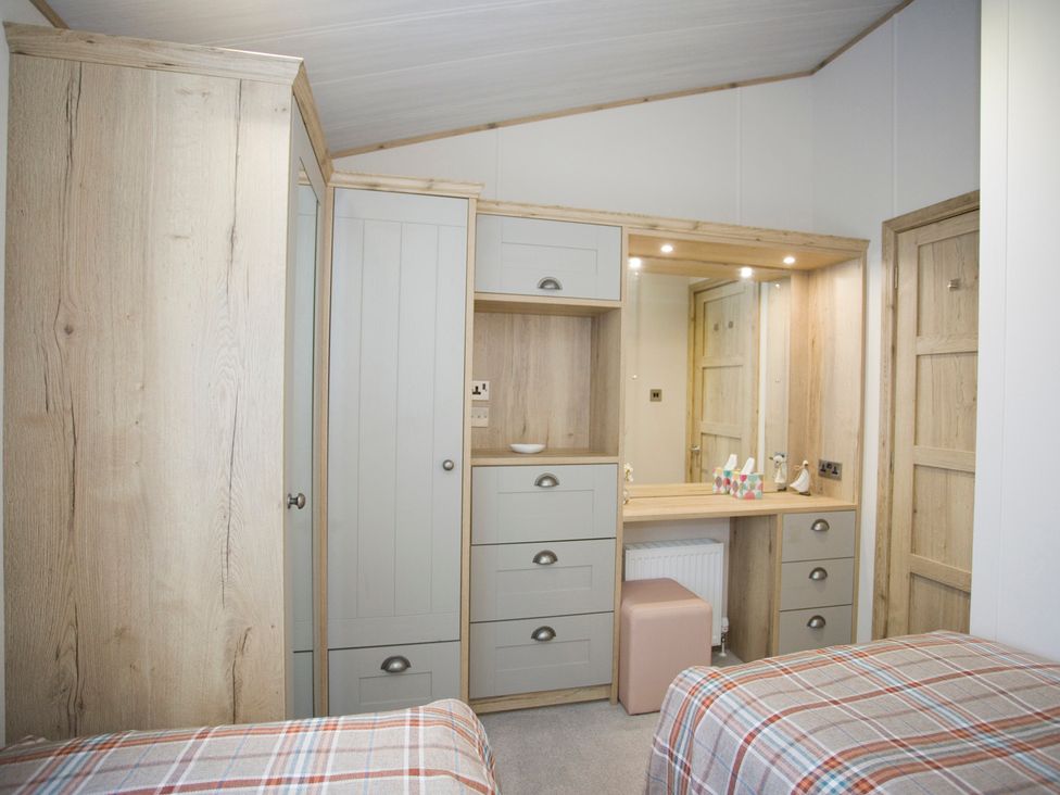 A bedroom with twin beds and a wardrobe at Orchid 9 Christchurch