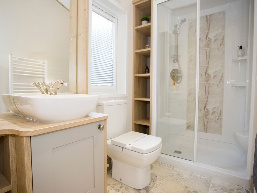 A bathroom with a sink, toilet, and shower at Orchid 9 in Christchurch