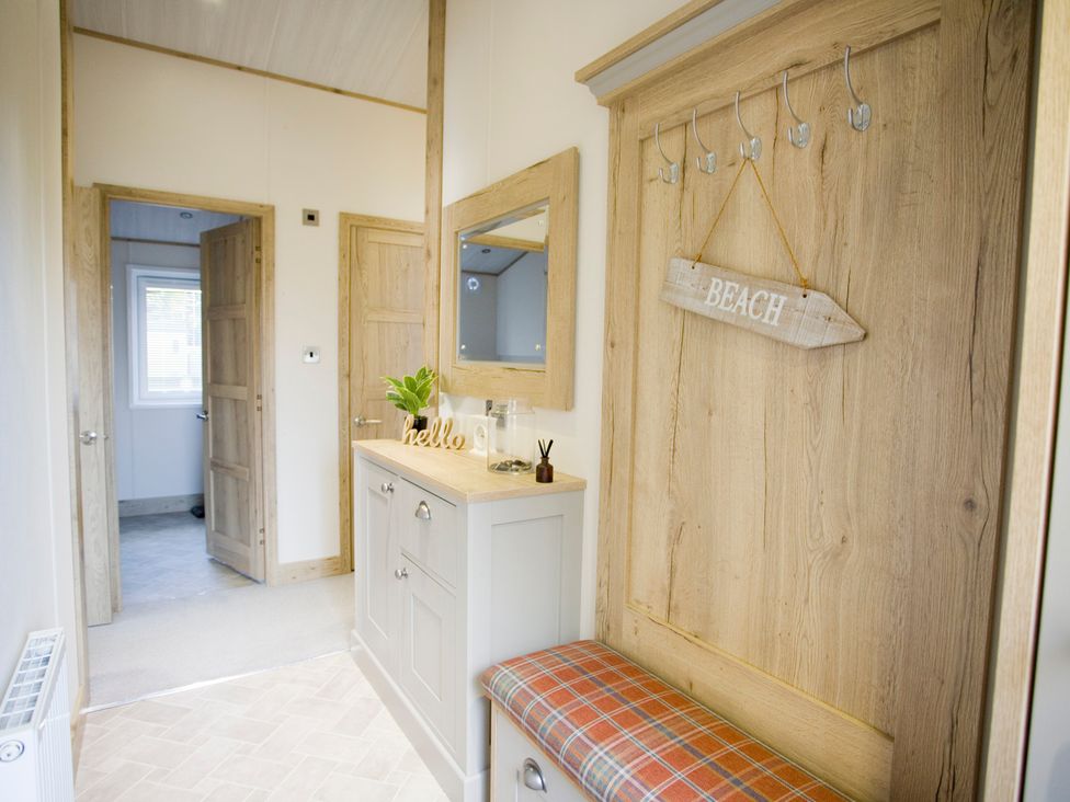 A hallway with a console table and hooks at Orchid 9 Christchurch