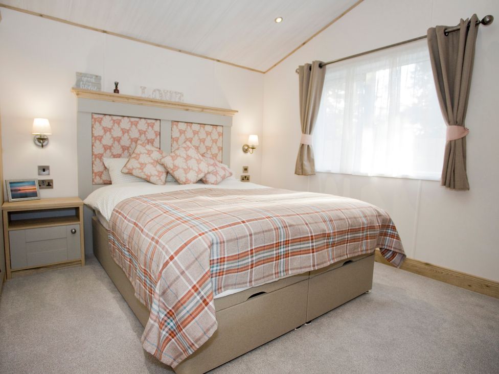 A bedroom with a bed and bedside table at Orchid 9 Christchurch