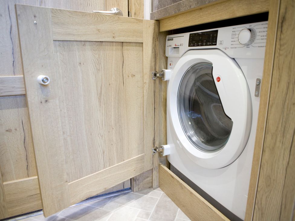 A washing machine inside a cupboard at Orchid 9 in Christchurch