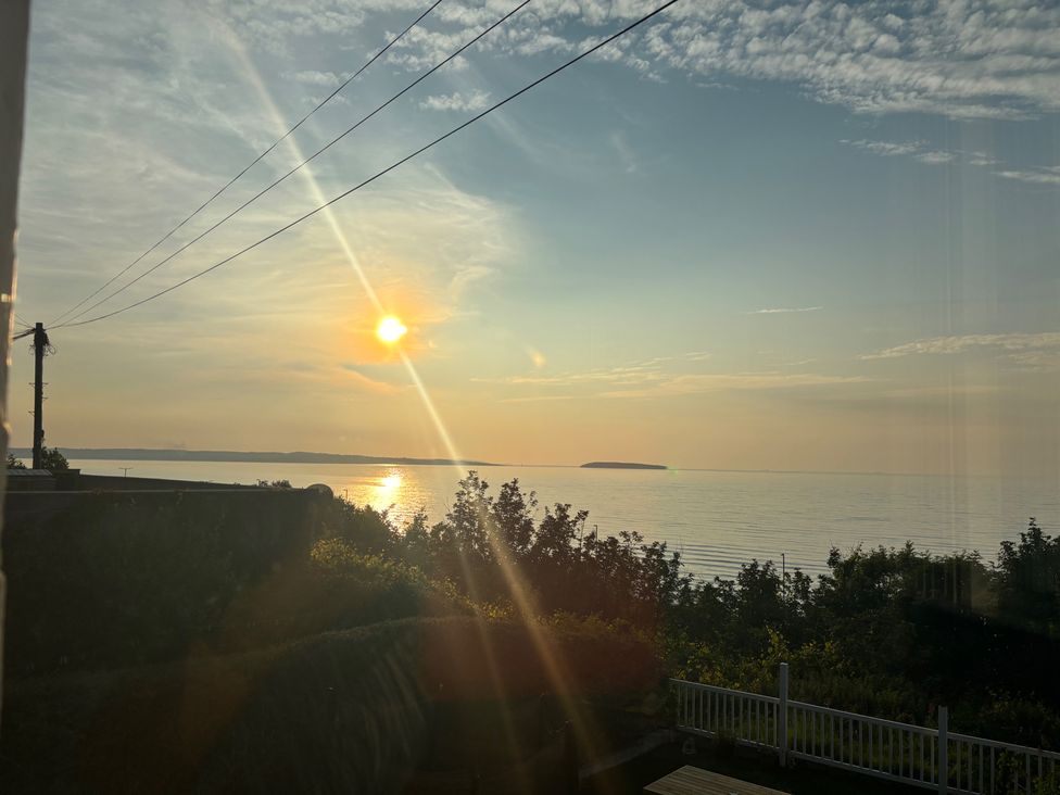 A seaside view with sunset and island at Penmaenmawr Coastal Retreat in 