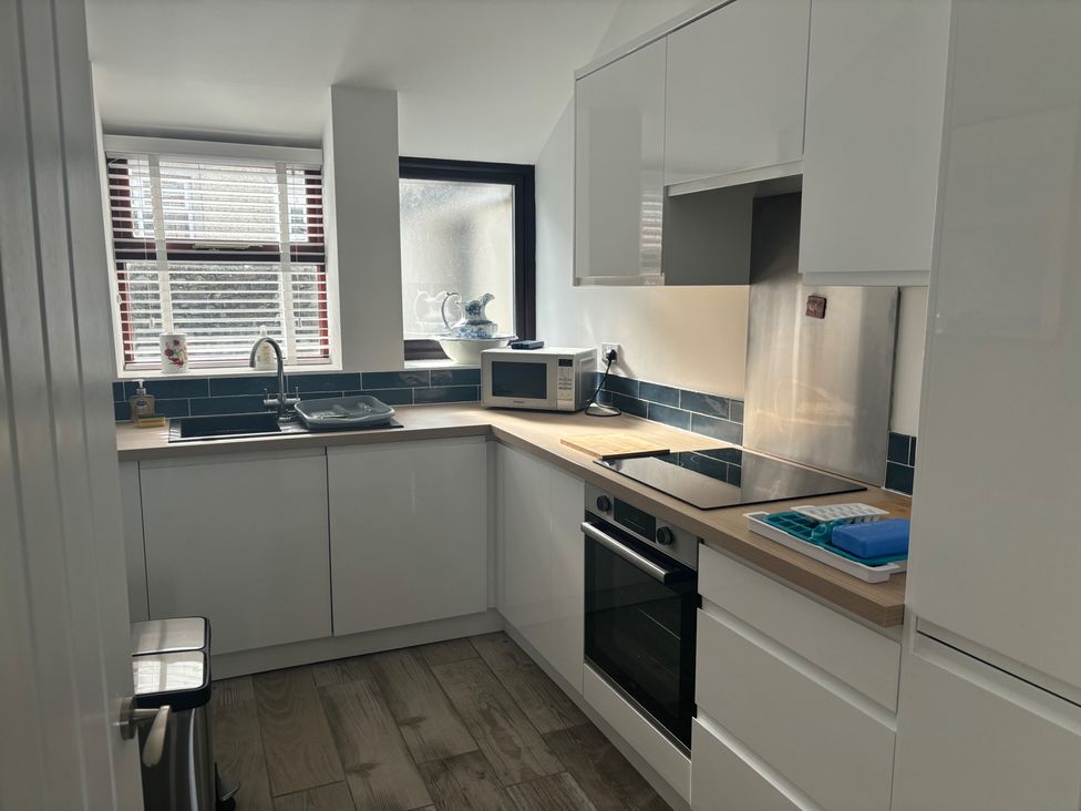 A kitchen with appliances and sink at Penmaenmawr Coastal Retreat