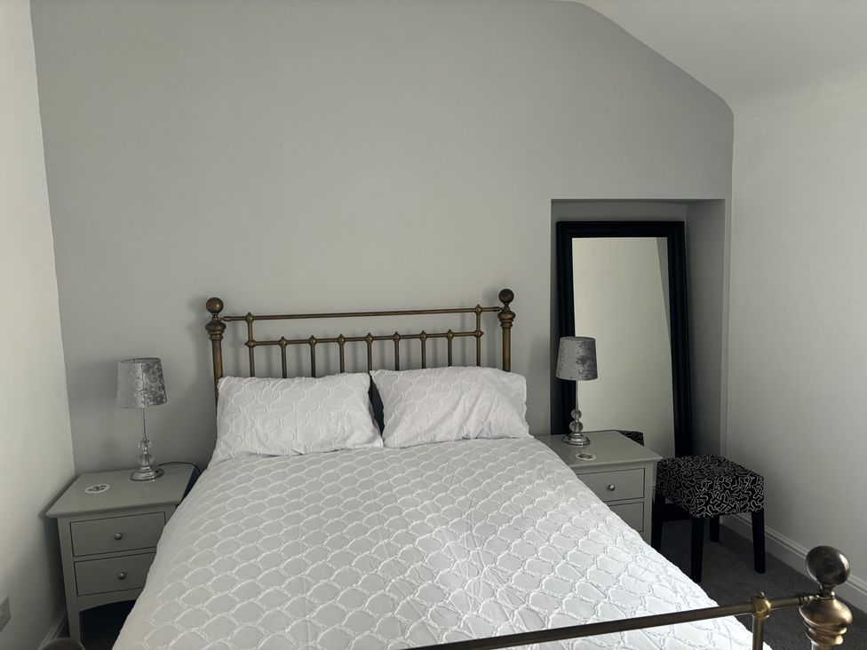 A bedroom with a bed and nightstand at Penmaenmawr Coastal Retreat 