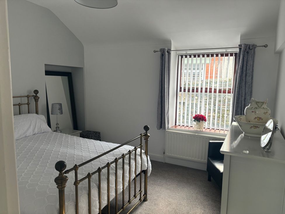 A bedroom with a bed and window at Penmaenmawr Coastal Retreat