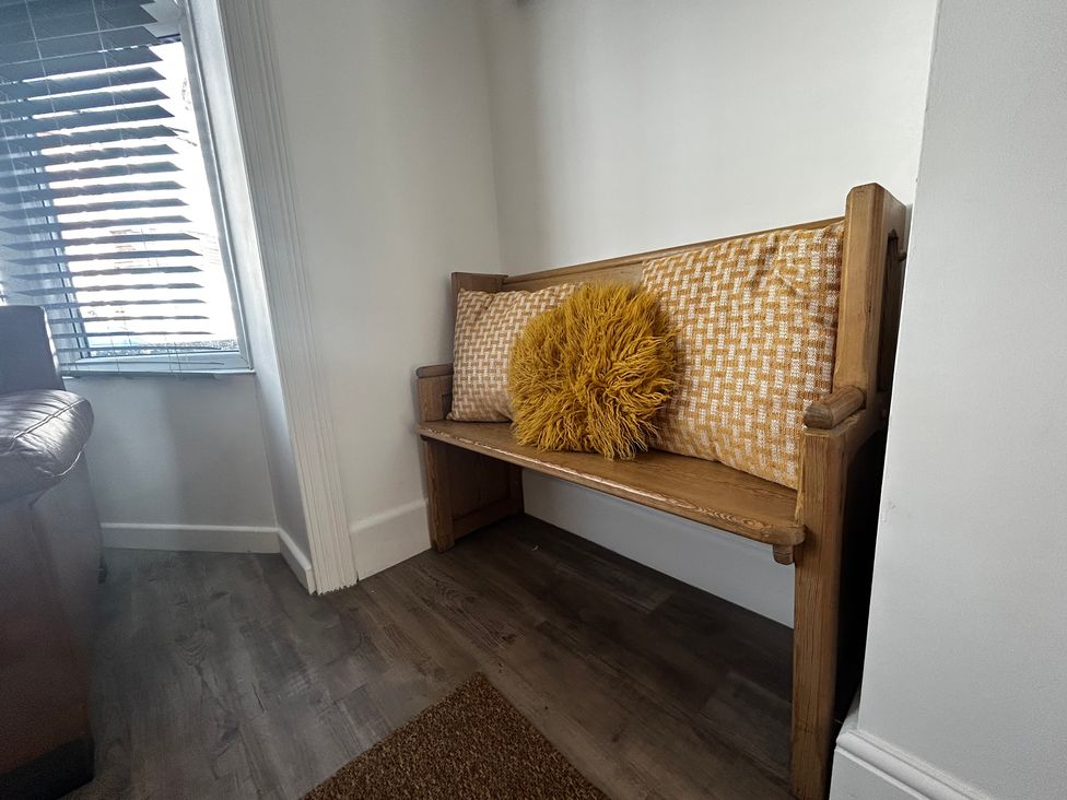 A bench with a cushion and pillow in a hallway at The Weymouth House in Weymouth