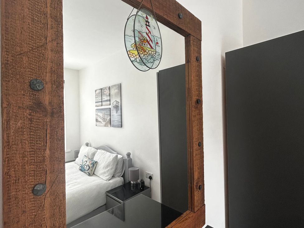 A bedroom with a bed and wall art at The Weymouth House in Weymouth
