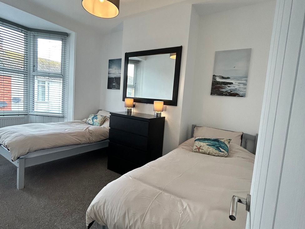 A bedroom with two beds and a dresser at The Weymouth House in Weymouth