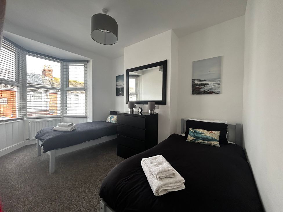 A bedroom with two beds and a dresser at The Weymouth House in Weymouth