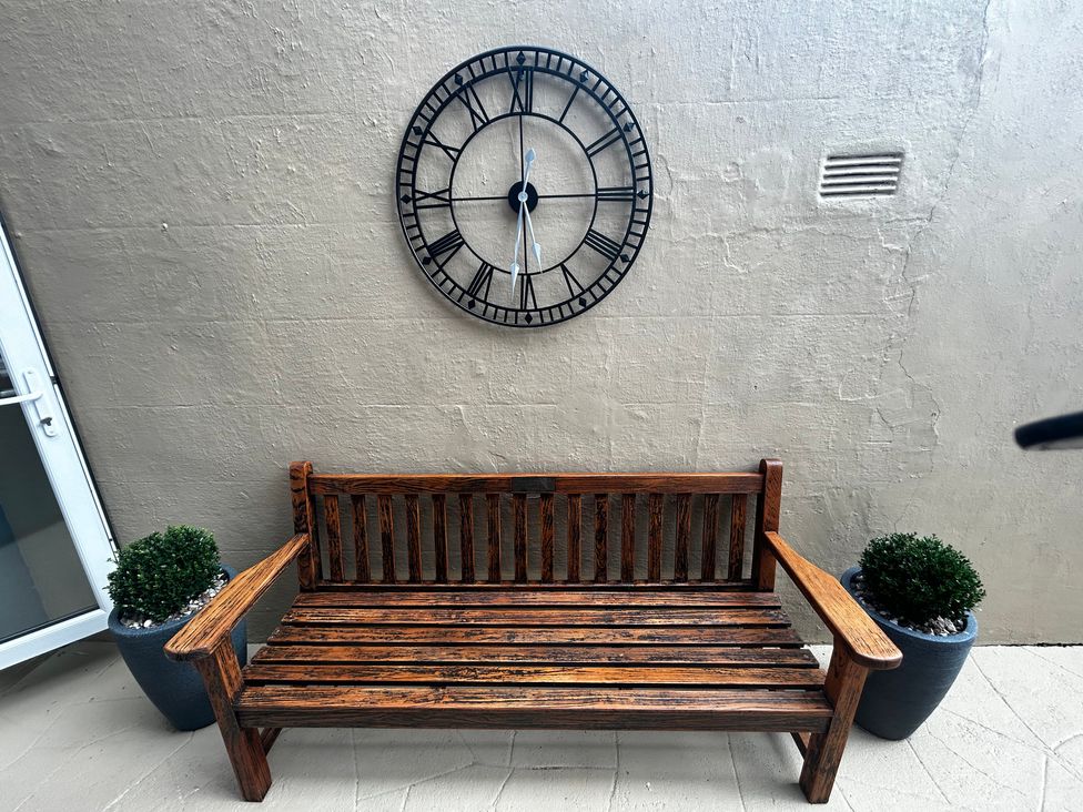 A bench with a clock on the wall at The Weymouth House in Weymouth