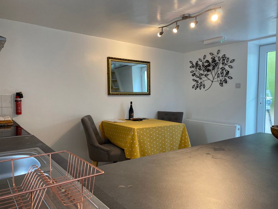 A kitchen with a dining area featuring a table and chairs at The Haven in Penrith