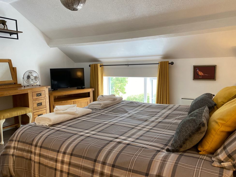 A bedroom with a bed, dresser, and television at The Haven in Penrith