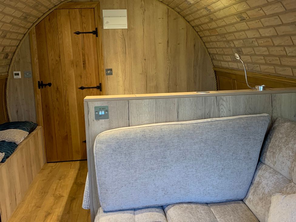 A room with a sofa and wooden door at Cosy Escape in Sheerness