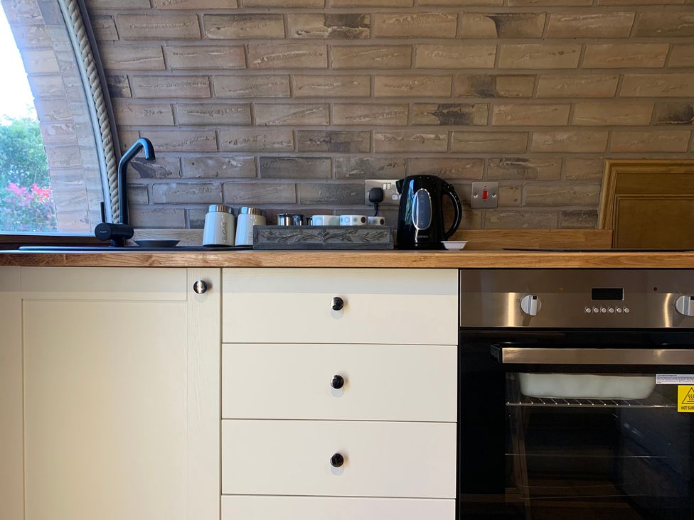 A kitchen with sink kettle and oven at Cosy Escape Sheerness