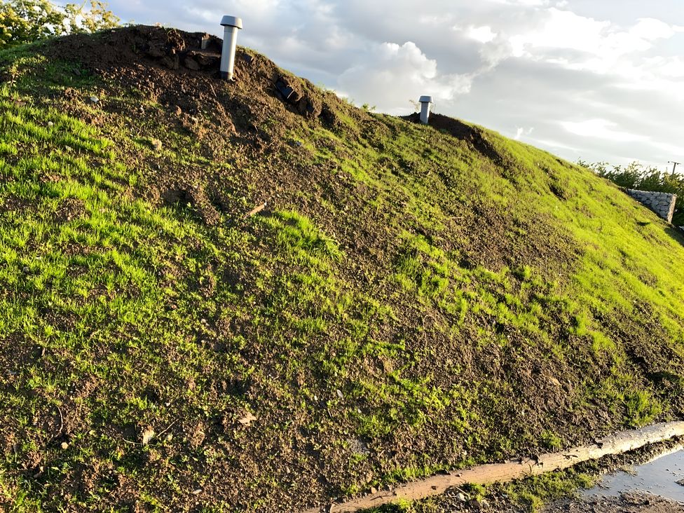 An earth mound with grass and a drainage pipe at Cosy Escape in Sheerness