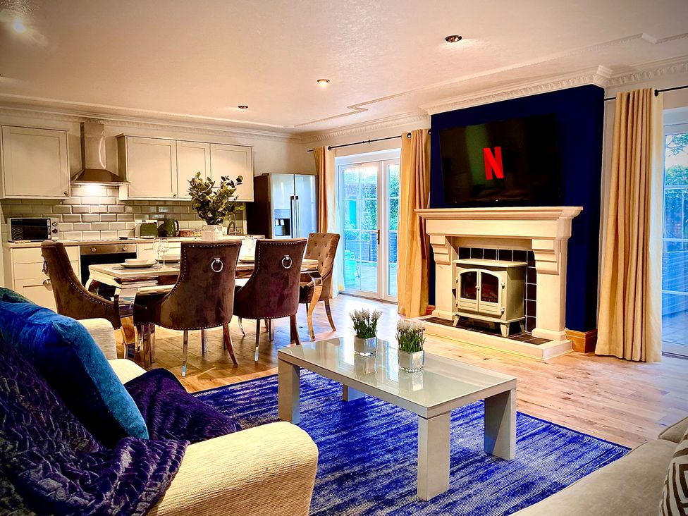 A living room with kitchenette featuring a dining area at Anchor Hot Tub Suite in Lytham St. Annes
