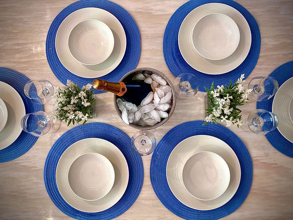 A dining table set with plates and drinks at Anchor Hot Tub Suite in Lytham St. Annes