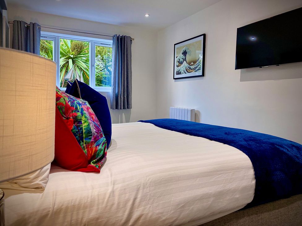 A bedroom with a bed and wall art at Anchor Hot Tub Suite in Lytham St. Annes