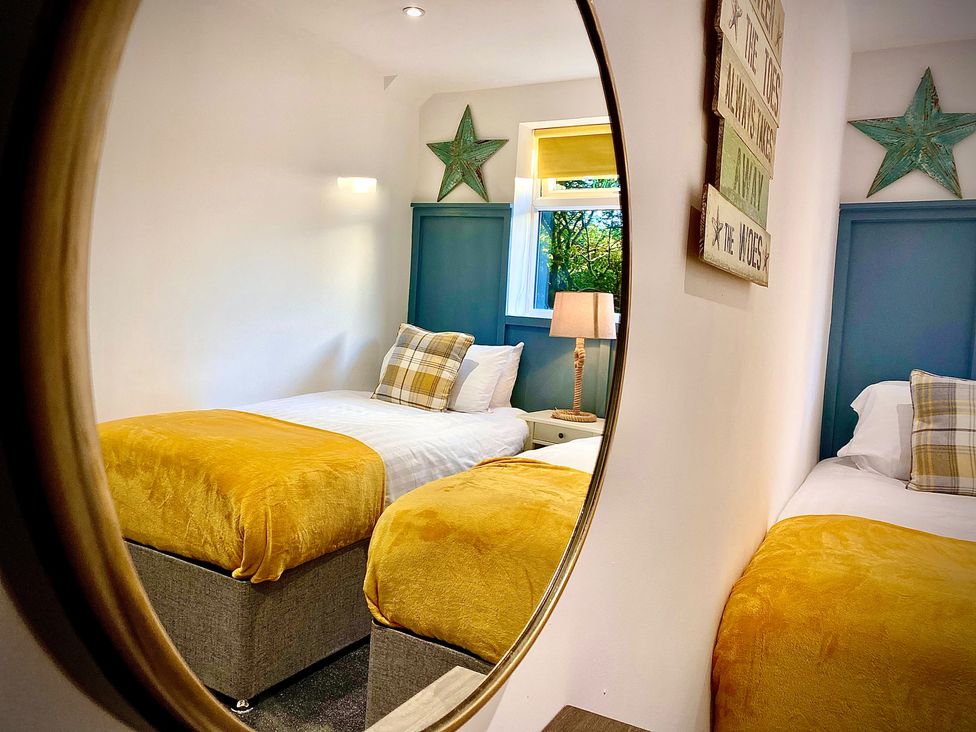 A bedroom with two beds and a lamp at Anchor Hot Tub Suite in Lytham St. Annes