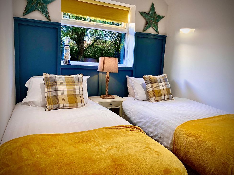 A bedroom with twin beds and a lamp at Anchor Hot Tub Suite in Lytham St. Annes