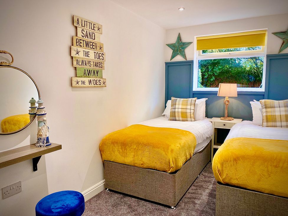 A bedroom with two beds and a decorative sign at Anchor Hot Tub Suite Lytham St. Annes