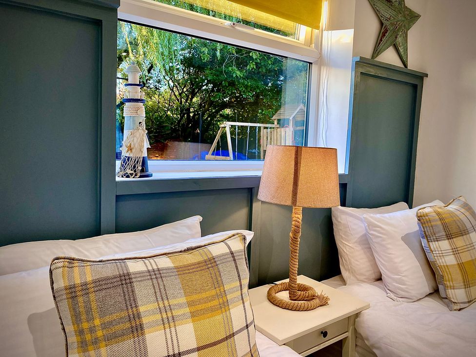 A bedroom with two beds and a lamp at Anchor Hot Tub Suite in Lytham St. Annes