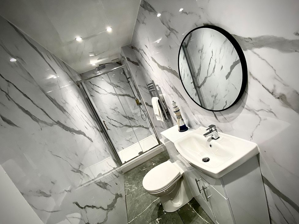 A bathroom with a shower, sink, and toilet at Anchor Hot Tub Suite in Lytham St. Annes