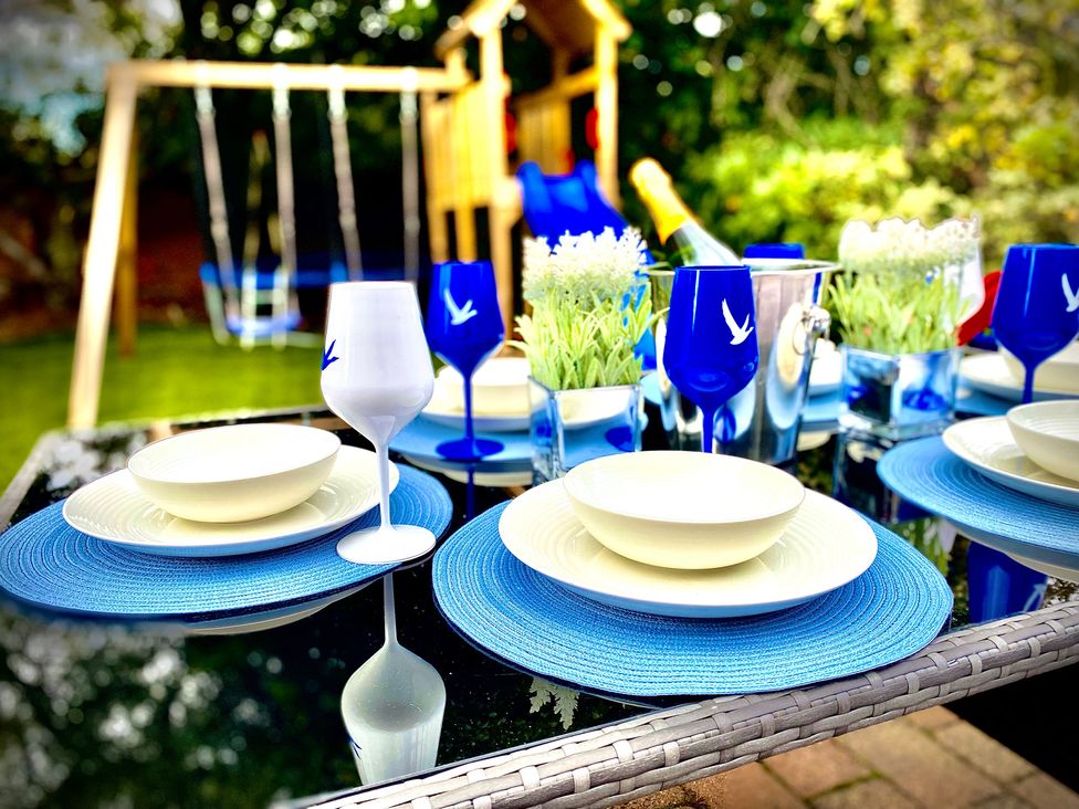 A dining table set in a garden at Anchor Hot Tub Suite Lytham St. Annes