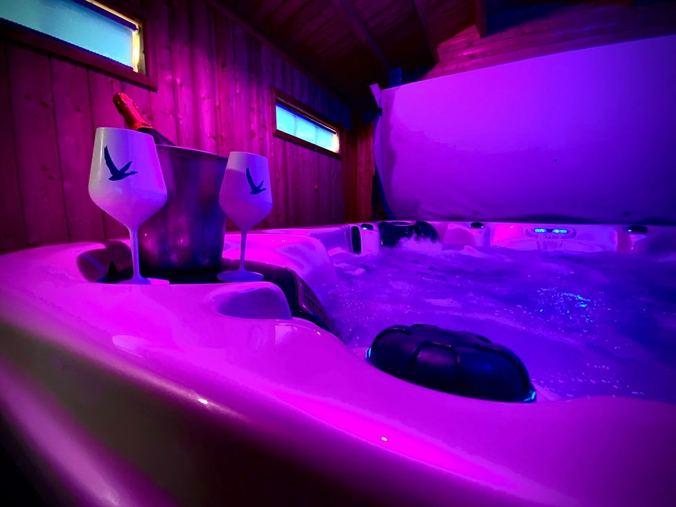 A hot tub with champagne glasses and an ice bucket at Anchor Hot Tub Suite in Lytham St. Annes