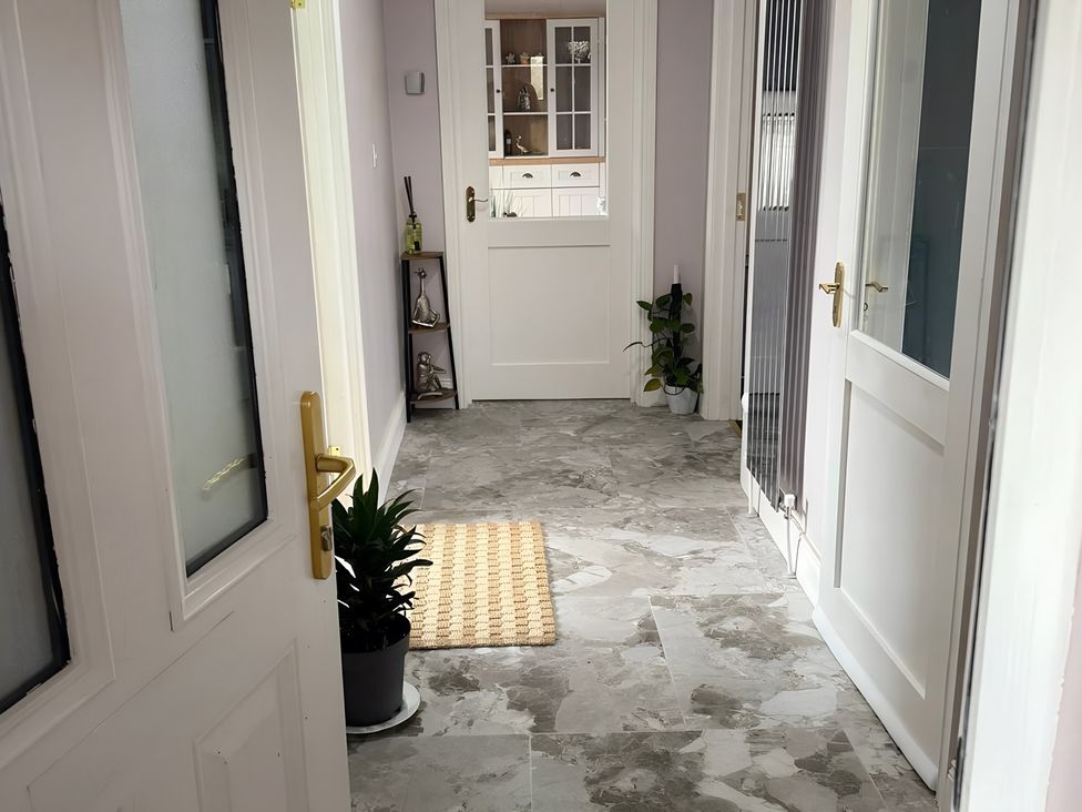 A hallway with doors and a shelf at Cherry Chirp Cottage Enniskillen