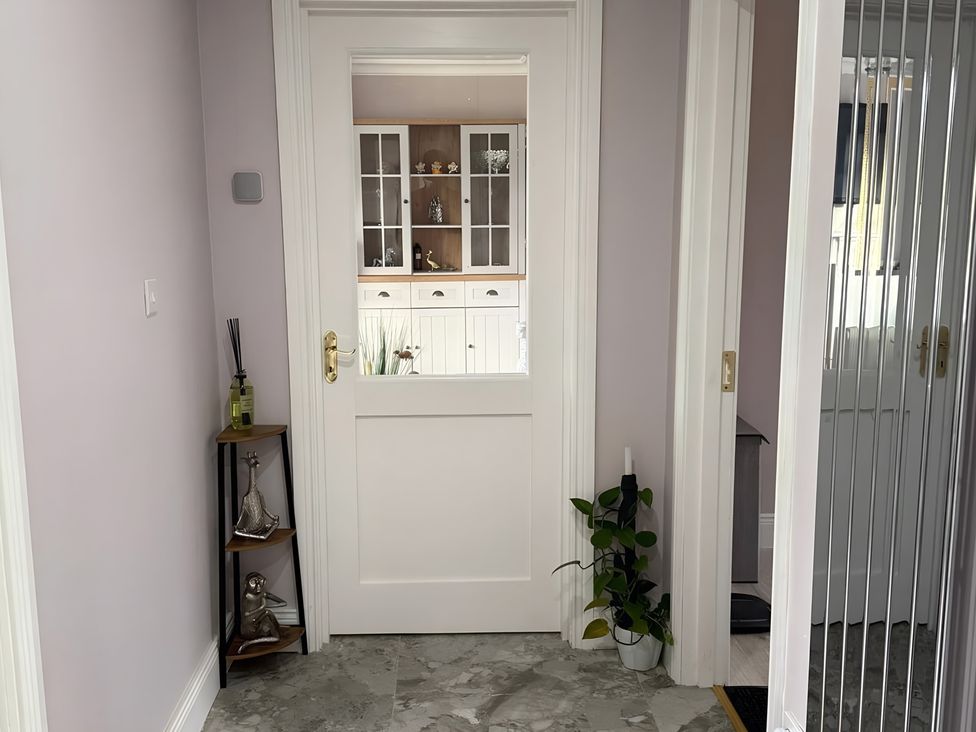 A hallway with a door and decorative items at Cherry Chirp Cottage Enniskillen