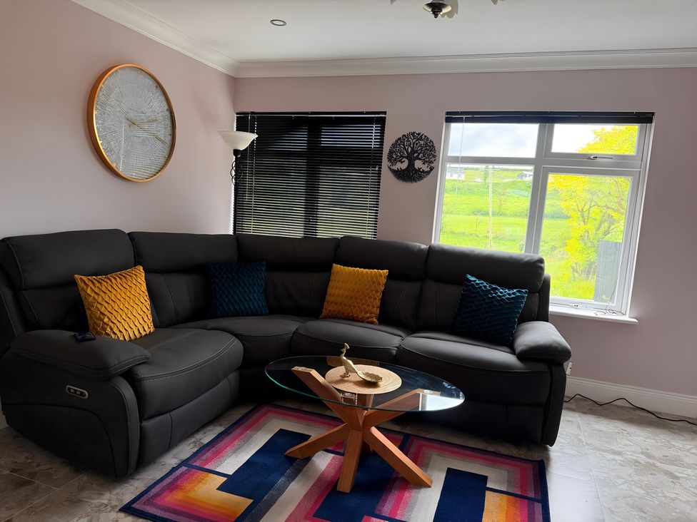 A living room with a sofa, cushions, and a coffee table at Cherry Chirp Cottage in Enniskillen