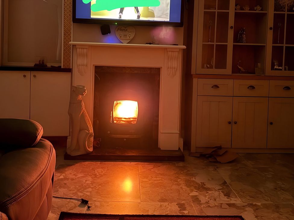 A living room with a fireplace and television at Cherry Chirp Cottage Enniskillen