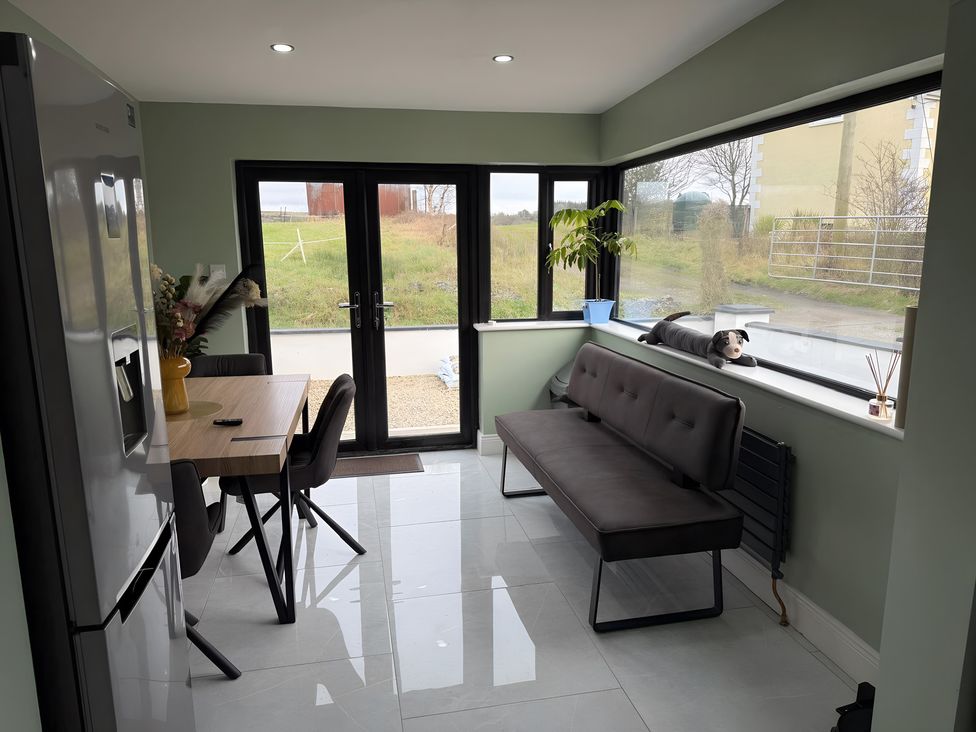 A dining room with a table and chairs at Cherry Chirp Cottage Enniskillen