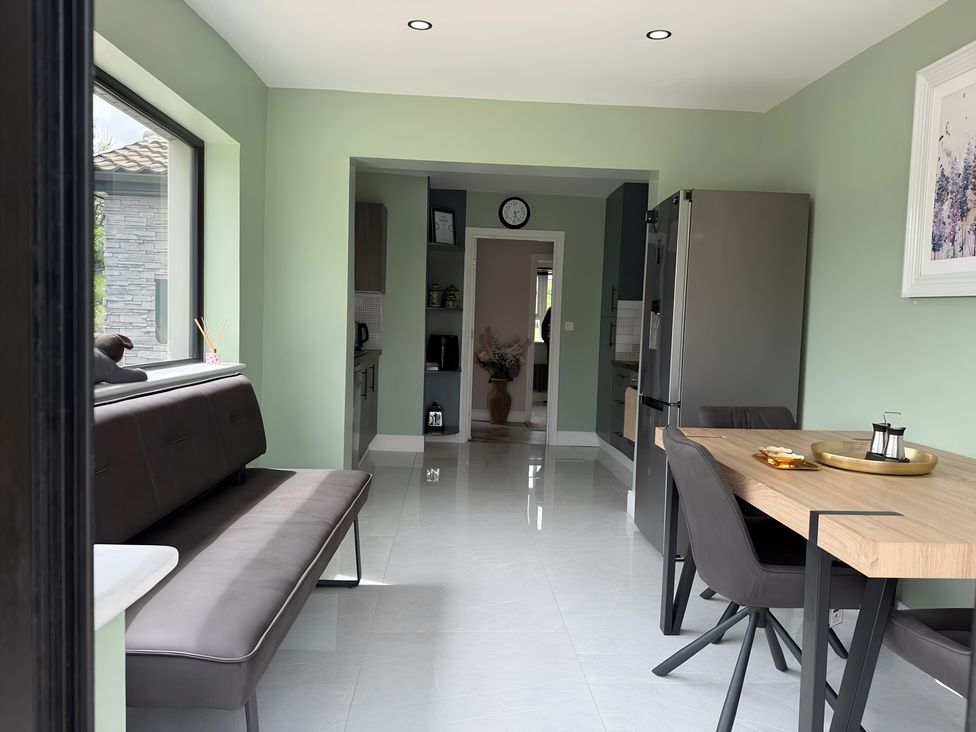 A kitchen with a dining table and fridge at Cherry Chirp Cottage Enniskillen