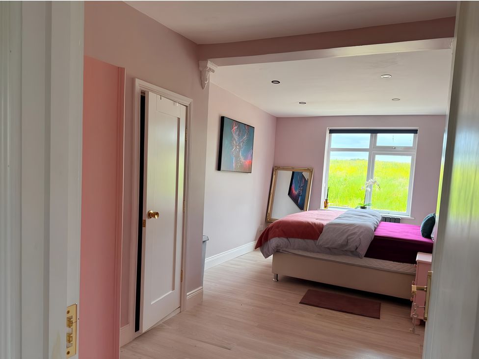 A bedroom with a bed and window at Cherry Chirp Cottage Enniskillen
