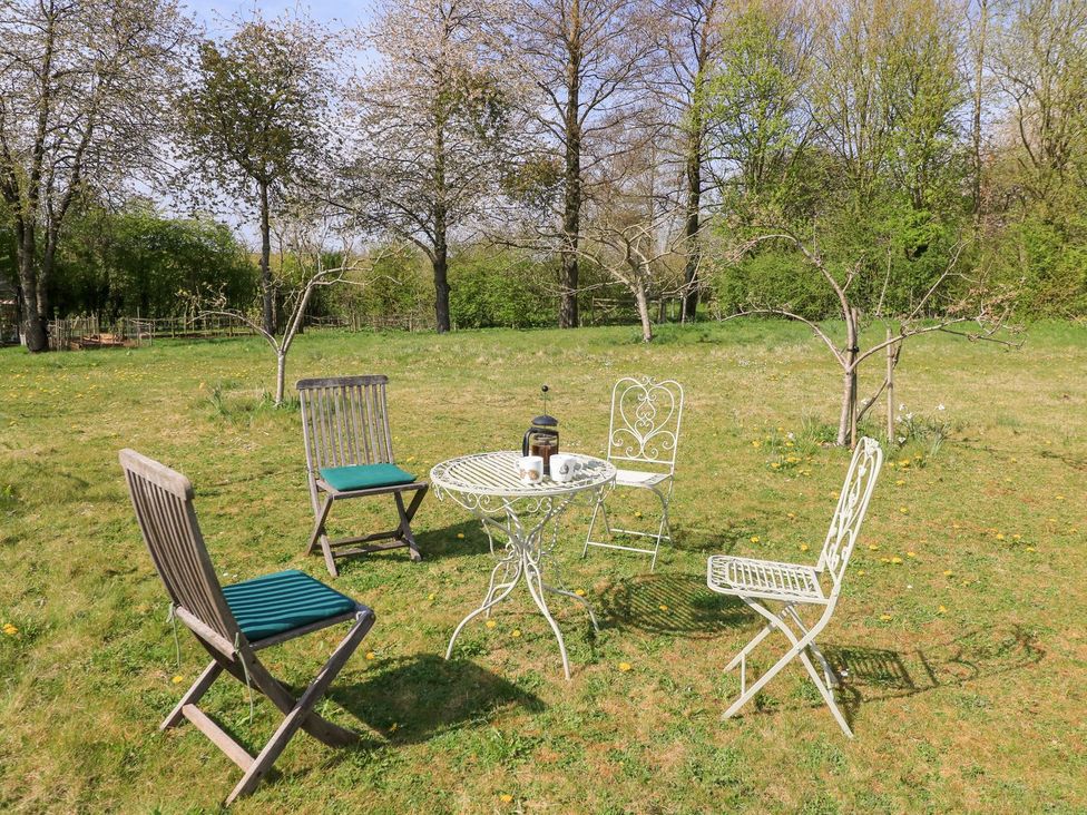 A garden with a table and chairs at Foxhill Farm Barn Cheltenham