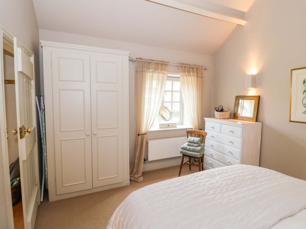 A bedroom with a bed, wardrobe, and window at Foxhill Farm Barn Bourton-On-The-Water