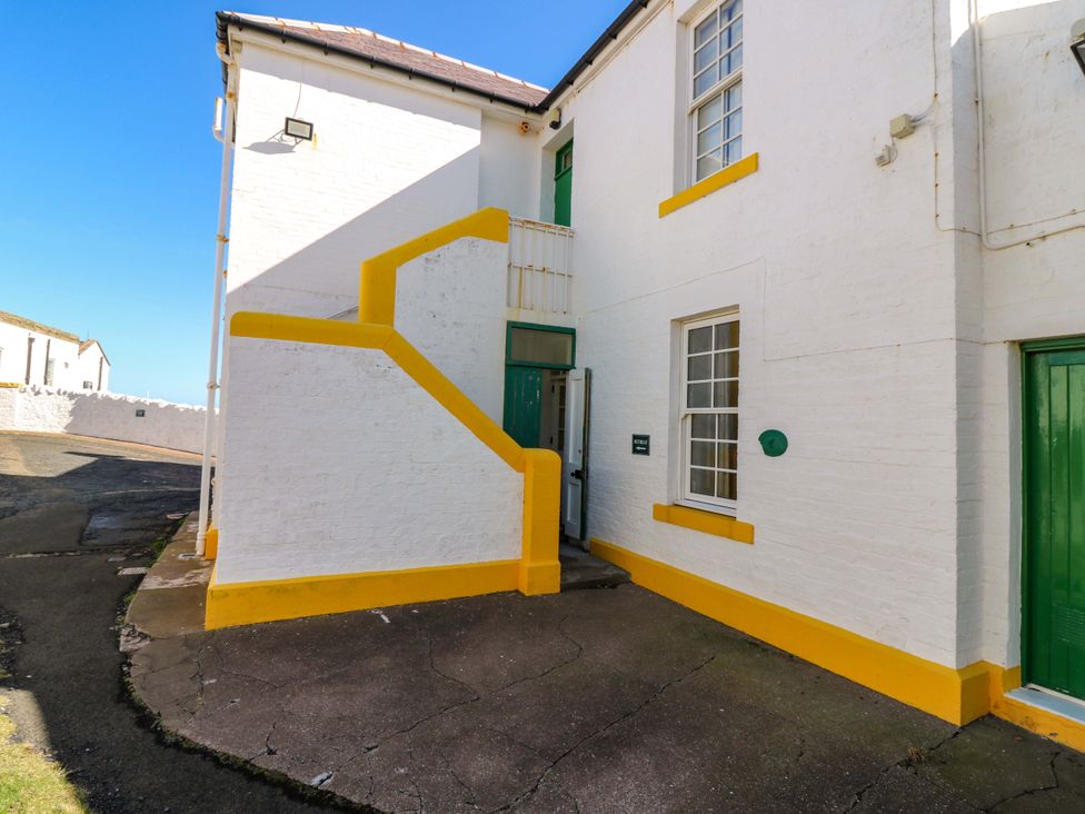An exterior view of a building with a staircase and door at The Lighthouse Retreat in St Abbs
