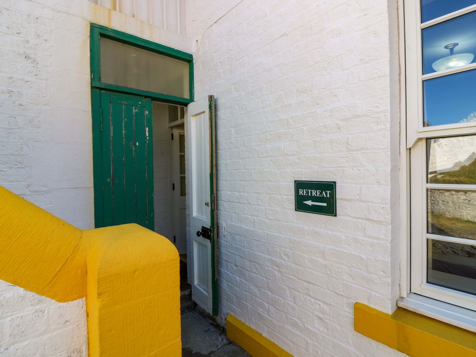 An entryway with green door and sign at The Lighthouse Retreat in St Abbs