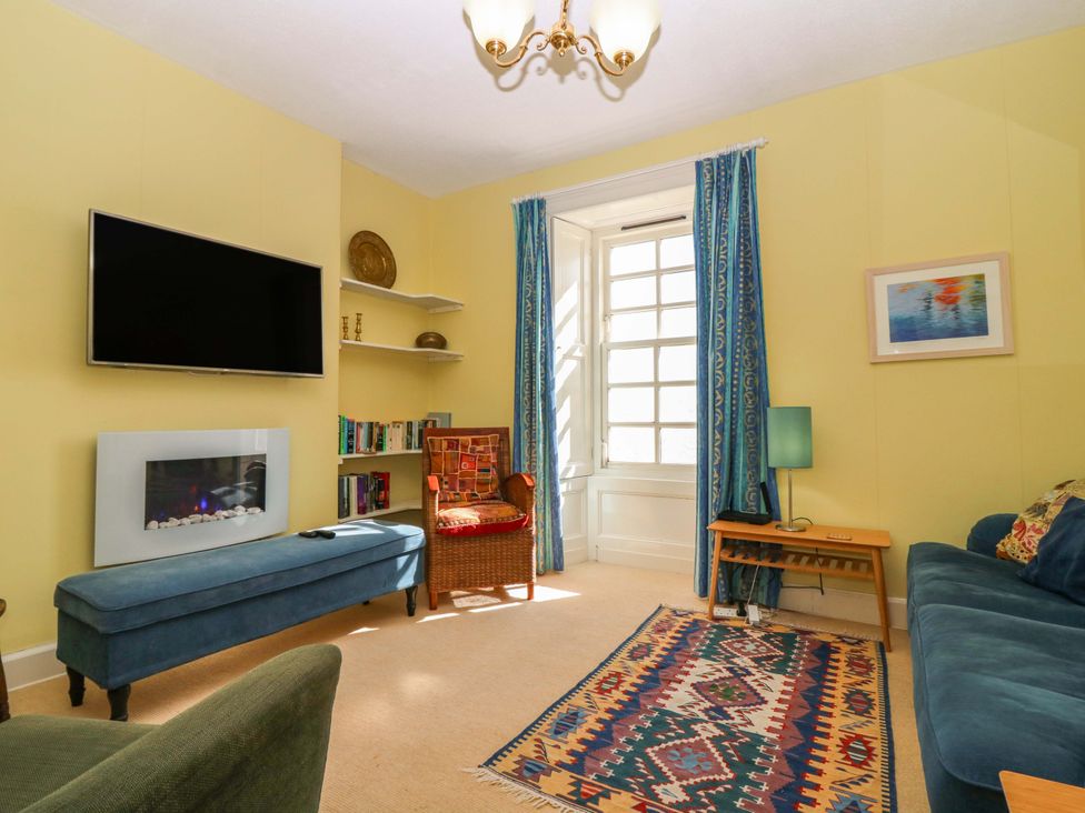 A living room with a television and a fireplace at The Lighthouse Retreat in St Abbs