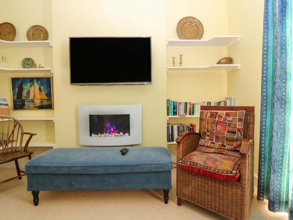 A living room with a television and a fireplace at The Lighthouse Retreat in St Abbs