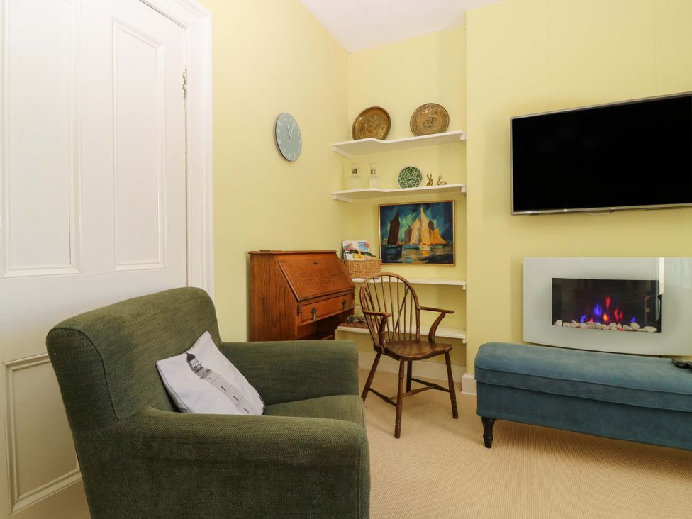 A living room with an armchair and television at The Lighthouse Retreat St Abbs
