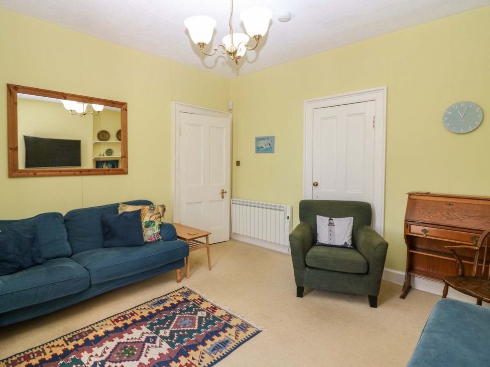 A living room with a sofa and armchair at The Lighthouse Retreat in St Abbs