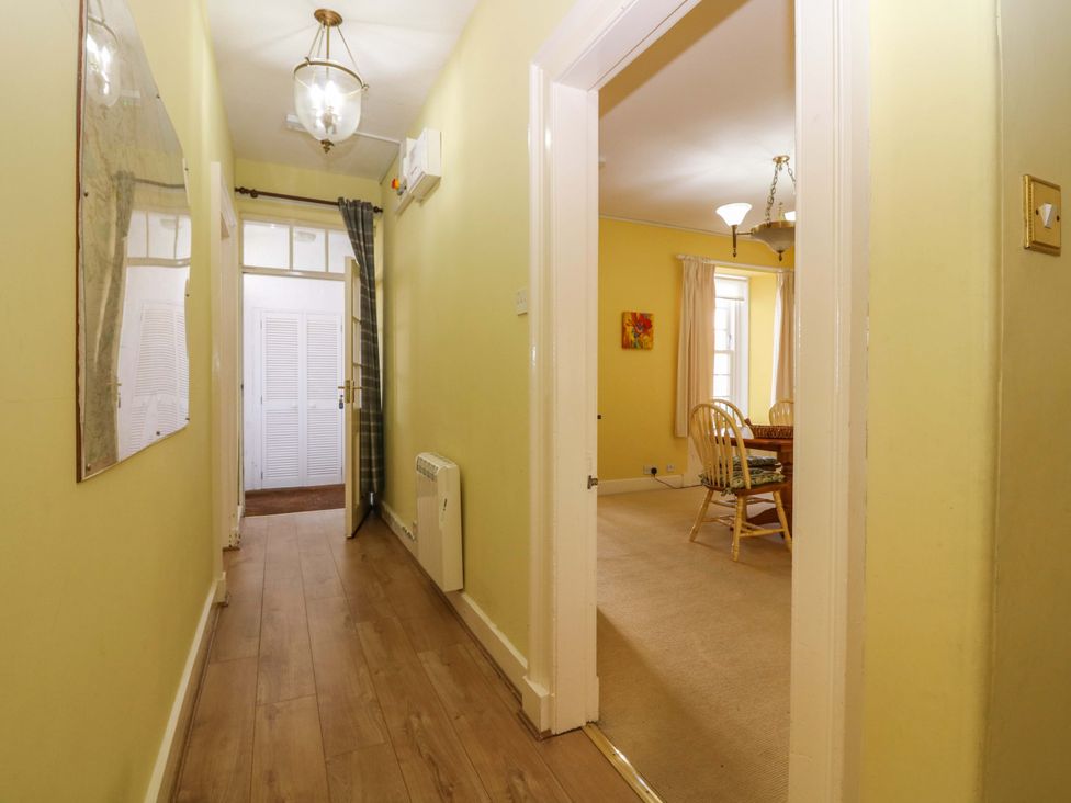 A hallway with a mirror and door at The Lighthouse Retreat in St Abbs