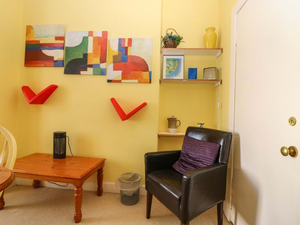 A sitting room with wall art and a table at The Lighthouse Retreat in St Abbs