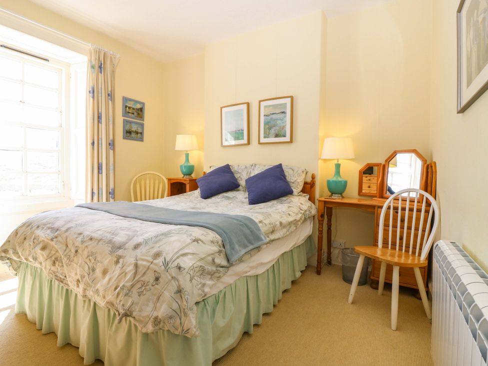 A bedroom with a bed and desk at The Lighthouse Retreat in St Abbs