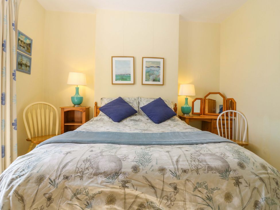 A bedroom with a bed and two chairs at The Lighthouse Retreat in St Abbs